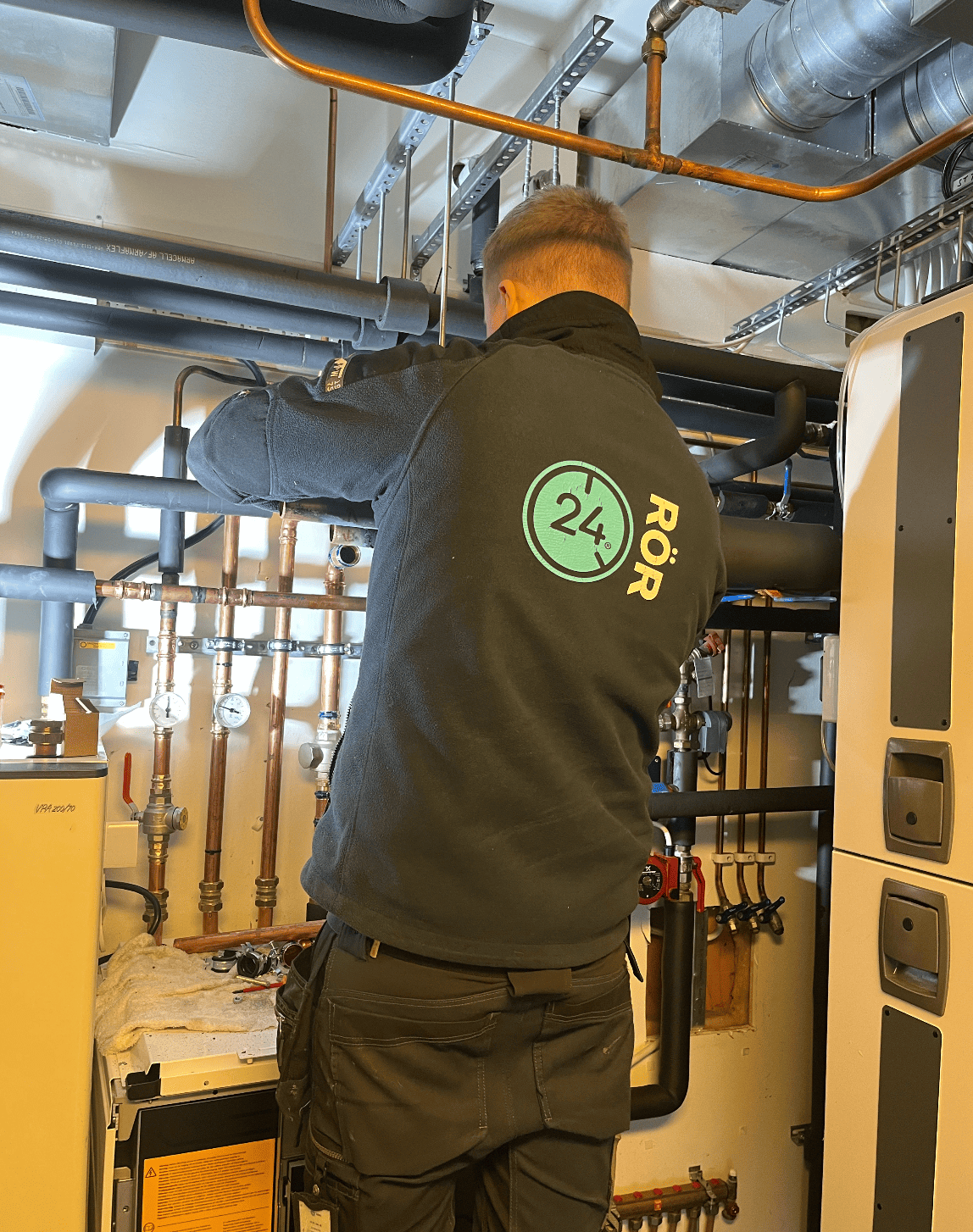Montör från 24 RÖR i undercentral, klädd i jacka med 24 RÖR-logo